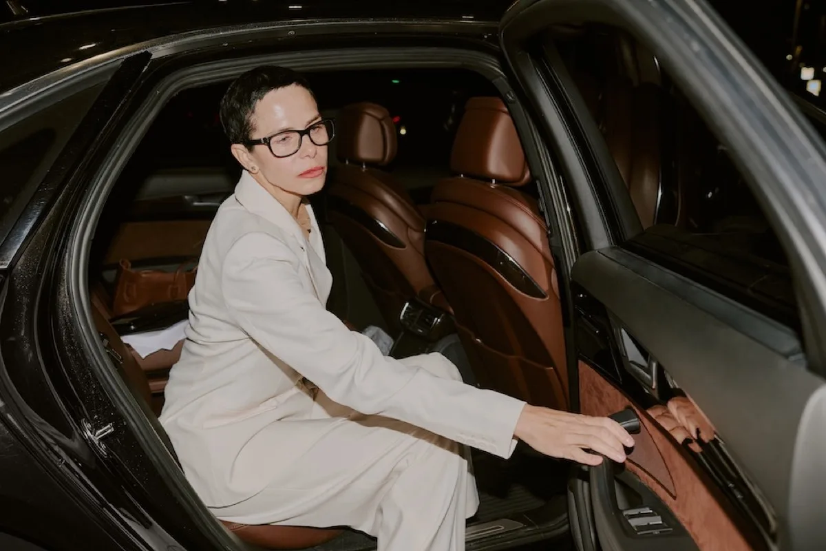 Elegantly dressed guest arriving at a London evening event in a chauffeur-driven luxury car